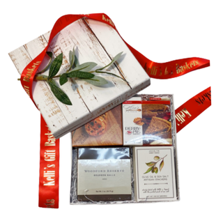 A gift box with a rustic wood appearance, adorned with a red ribbon, containing various food items including packaged bourbon balls, a pie tart, cheese, crackers, and a cheese spreader.