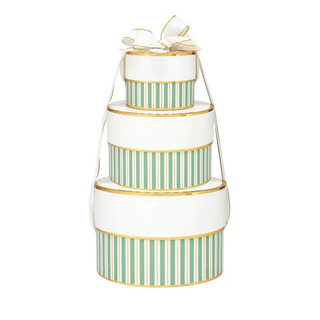 Three stacked round gift boxes with white bodies, mint green vertical stripes, and gold trim, topped with a white ribbon and bow on a plain white background.